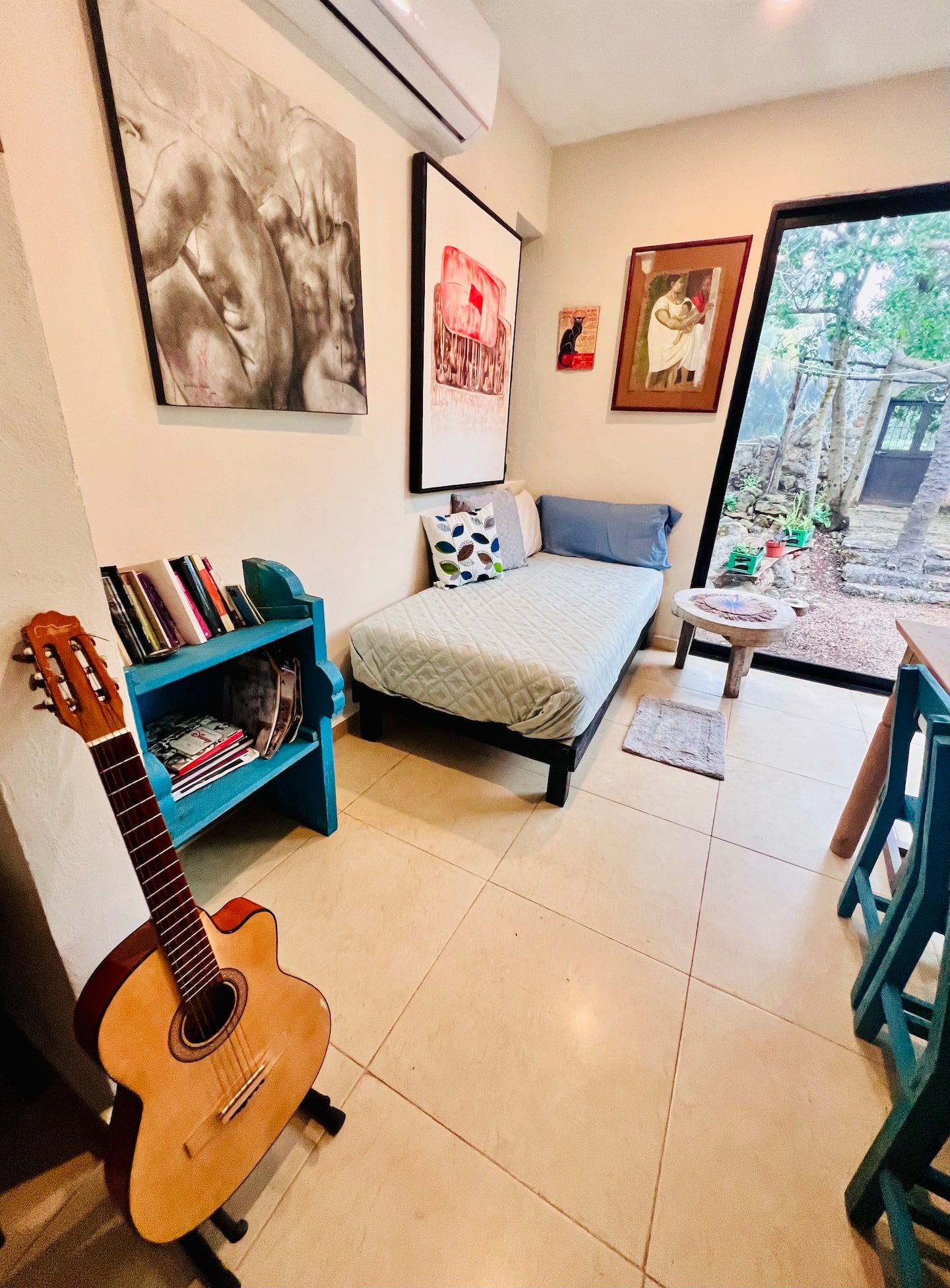 Rincón con guitarra y biblioteca sobre Aké